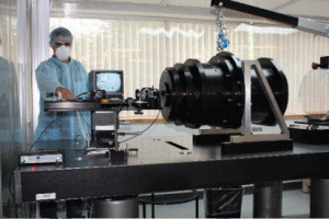 The 6-element, 250 lb, APOGEE refractive camera undergoes interferometric null-testing at New England Optical Systems, Inc.