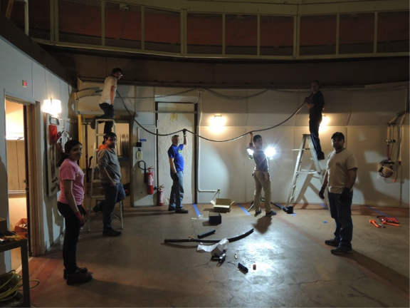 Utilization of the du Pont telescope required retrofitting to accommodate the needed infrastructure. Here, the fiber train, which runs between the telescope and the instrument located one floor below, is installed along the perimeter of the observing floor during commissioning. <em>Photo courtesy of J. Wilson.</em>