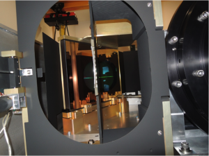 A view inside the APOGEE-South instrument looking towards the pseudo-slit.  The VPH grating can be seen in reflection focused on Fold Mirror 2.  The Camera barrel is to the right. <em>Photo courtesy of J. Wilson.</em> 