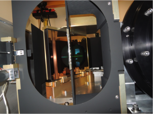 A view inside the APOGEE-South instrument looking towards the pseudo-slit. The VPH grating can be seen in the reflection off of Fold Mirror 2. The Camera barrel is to the right. <em>Photo courtesy of J. Wilson.</em>