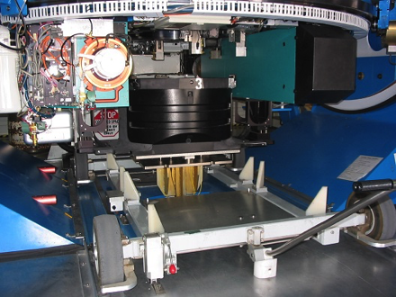A cartridge is pneumatically lifted into place on the Sloan Foundation Telescope after being maneuvered into place under the telescope with the cart. <em>Photo courtesy of J. Wilson.</em>
