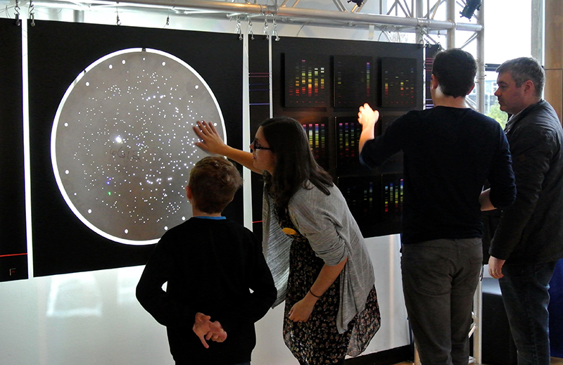 A teacher shows a student an SDSS plug plate as part of a museum exhibit